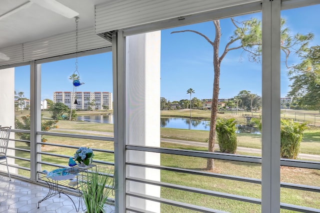 sunroom / solarium featuring a water view