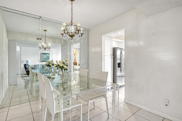 dining area with light tile patterned flooring, a textured ceiling, and an inviting chandelier