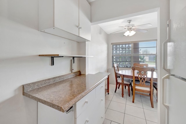 kitchen with white cabinets, ceiling fan, vaulted ceiling, light tile patterned flooring, and white fridge