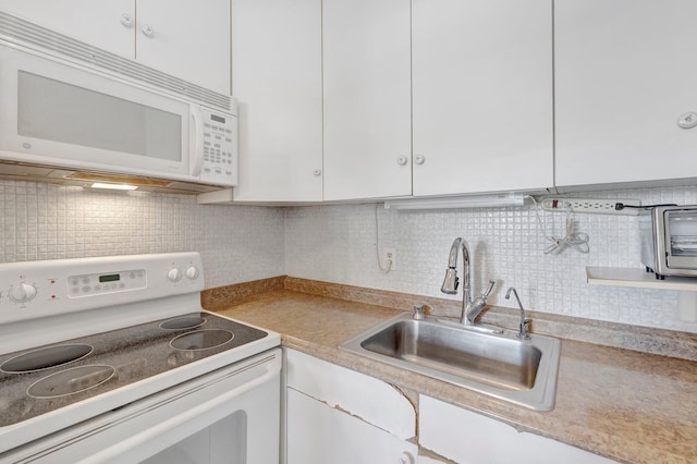 kitchen featuring white appliances, tasteful backsplash, sink, and white cabinets