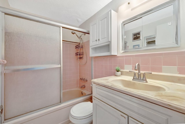 full bathroom featuring tasteful backsplash, a textured ceiling, toilet, enclosed tub / shower combo, and vanity