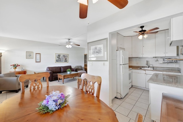 dining room with light tile patterned floors, sink, and ceiling fan