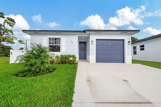 166 Neva Dr, West Palm Beach, FL 33415 - view of front of home with driveway, a front yard, stucco siding, and a garage