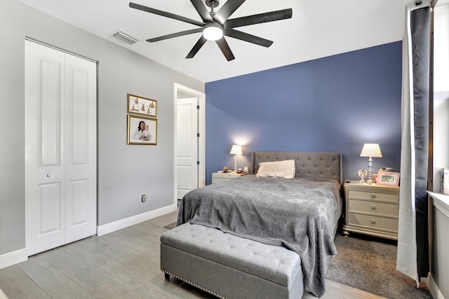 bedroom featuring a closet, light hardwood / wood-style floors, and ceiling fan