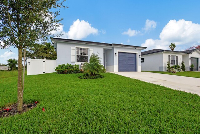 166 Neva Dr, West Palm Beach, FL 33415 - view of front of house with stucco siding, concrete driveway, and an attached garage