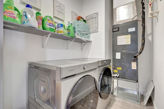 laundry room with washer and dryer and light wood-type flooring