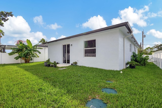 back of property featuring a lawn