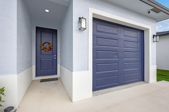 view of exterior entry with a garage