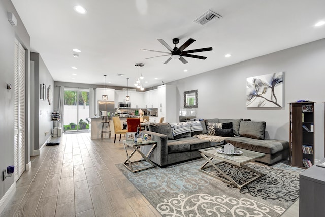 living room featuring light hardwood / wood-style floors and ceiling fan