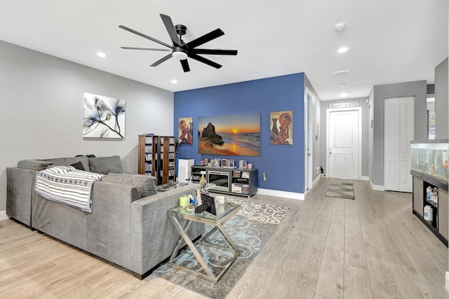 living room featuring light hardwood / wood-style flooring and ceiling fan