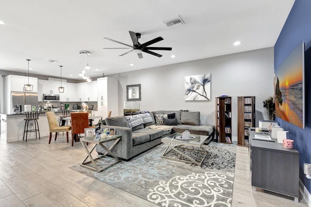 living room with light hardwood / wood-style flooring and ceiling fan