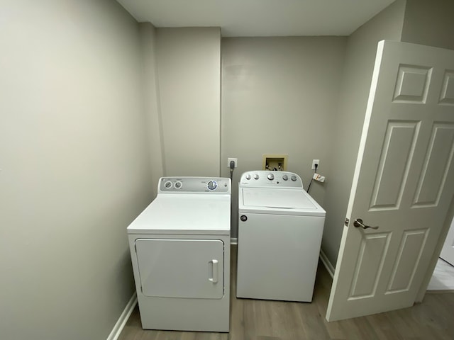 laundry area featuring washer and dryer and light wood-type flooring