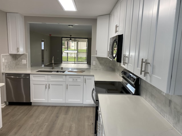 15324 Lakes Of Delray Blvd Unit 104, Delray Beach, FL 33484 - kitchen featuring appliances with stainless steel finishes, a sink, white cabinets, and tasteful backsplash