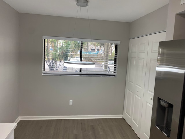 unfurnished dining area featuring dark wood-type flooring