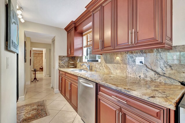 kitchen featuring sink, light tile patterned floors, stainless steel dishwasher, light stone counters, and tasteful backsplash