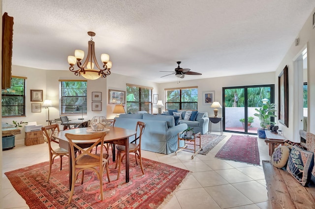 dining space featuring a textured ceiling, ceiling fan with notable chandelier, and light tile patterned floors