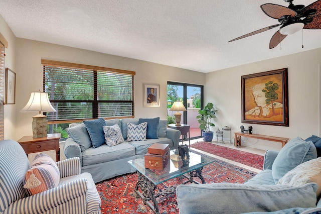 living room featuring ceiling fan and a textured ceiling