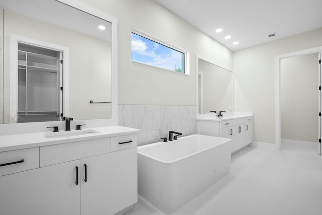 bathroom featuring vanity, tile patterned flooring, and a washtub