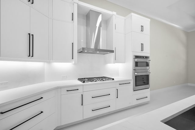 kitchen with white cabinetry, wall chimney exhaust hood, and stainless steel appliances