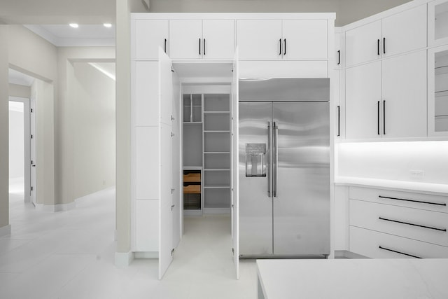 kitchen with light tile patterned floors, white cabinets, and stainless steel built in fridge