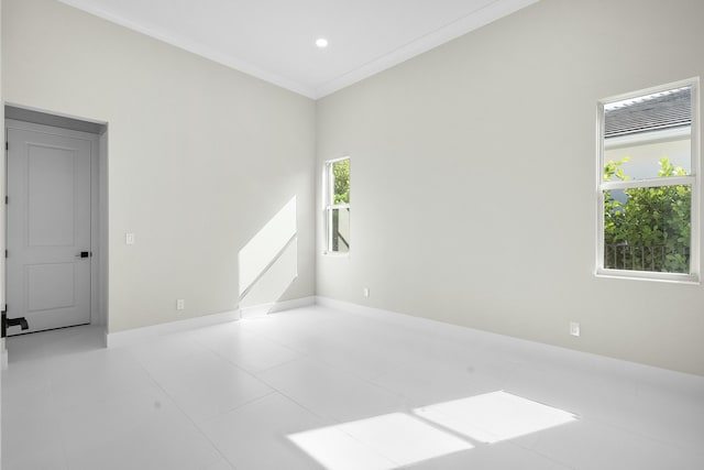 spare room with light tile patterned floors and crown molding