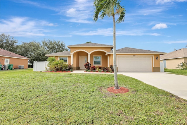 view of front of home with a front lawn, central AC, and a garage