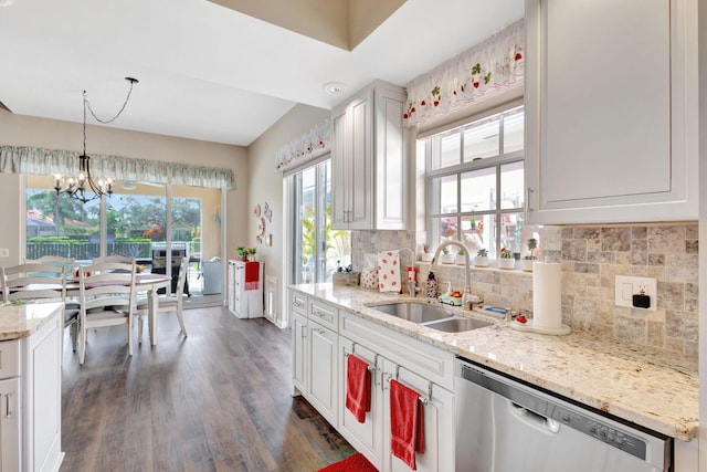 kitchen featuring stainless steel dishwasher, a sink, dark wood-style floors, a chandelier, and backsplash