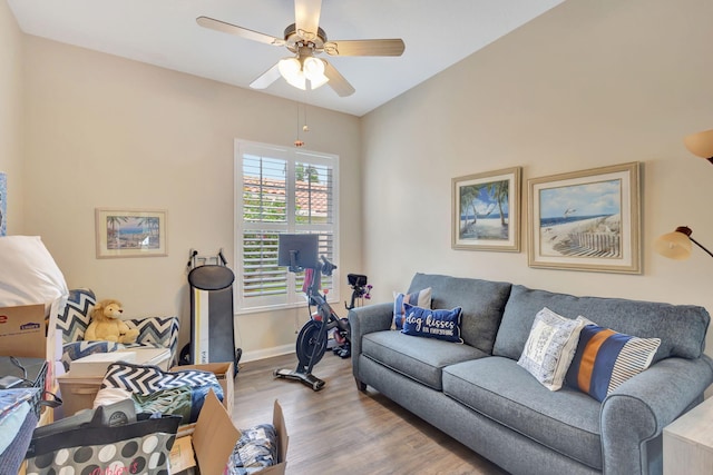 living area featuring wood finished floors, ceiling fan, and baseboards