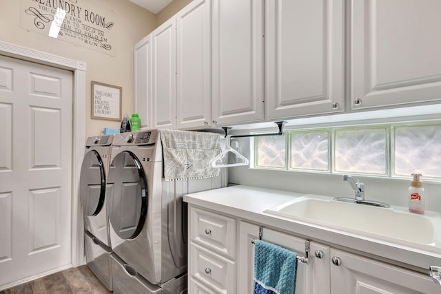 laundry room with hardwood / wood-style flooring, cabinets, sink, and washing machine and clothes dryer