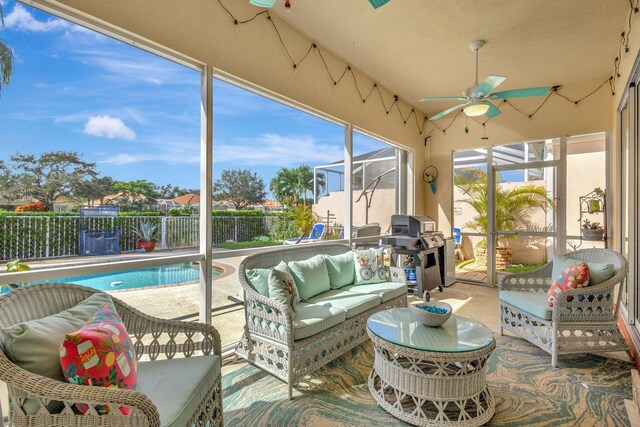 sunroom with ceiling fan and an outdoor living space