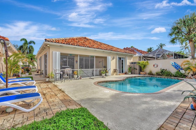 view of pool with a patio area, a fenced backyard, and a sunroom