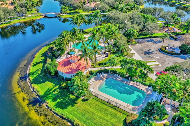 drone / aerial view of a pool and a nearby body of water
