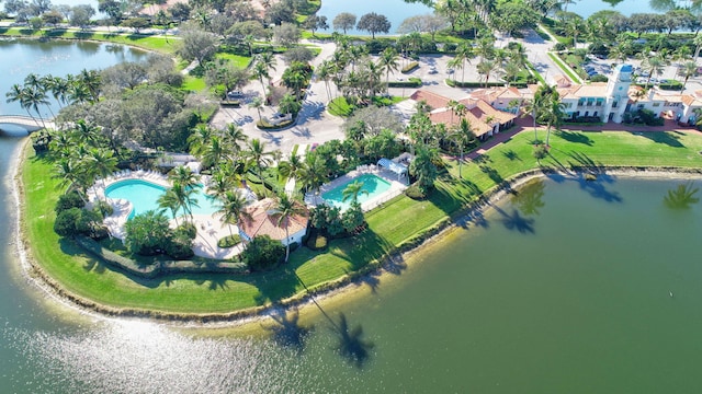 aerial view of property and surrounding area with a pool area and a large body of water