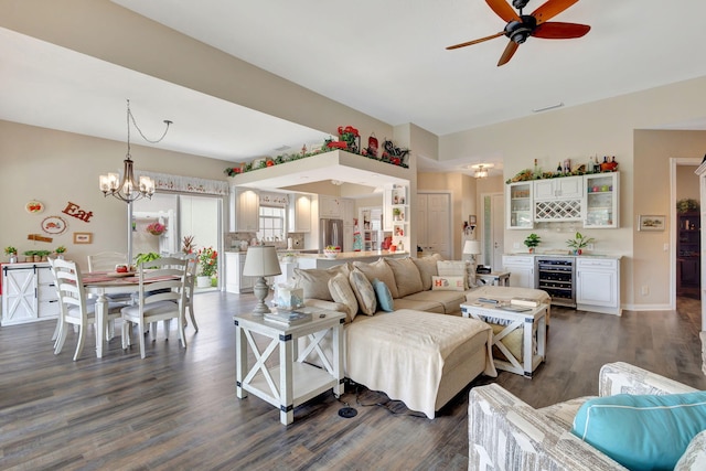 living room with wine cooler, ceiling fan, a dry bar, dark wood-type flooring, and a chandelier