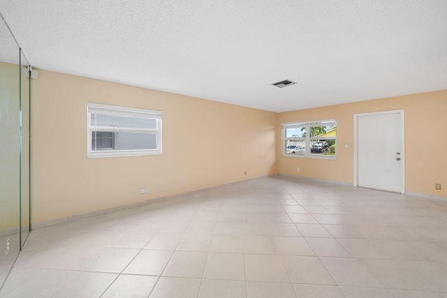 tiled spare room with a textured ceiling