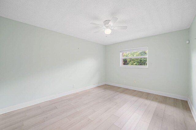 spare room with a textured ceiling, light hardwood / wood-style flooring, and ceiling fan