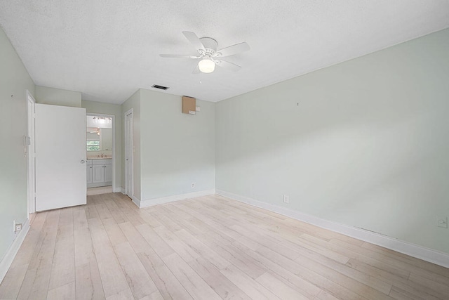 spare room featuring a textured ceiling, ceiling fan, light wood-type flooring, and sink