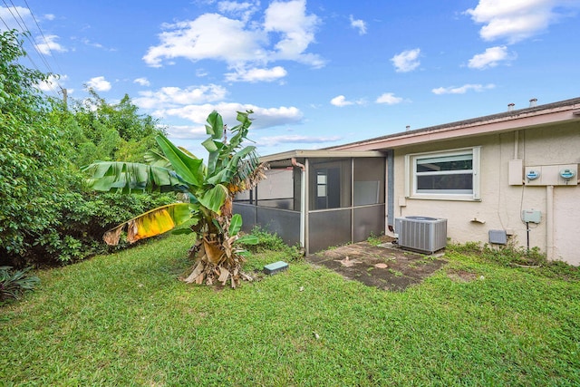 view of yard with central AC unit and a sunroom