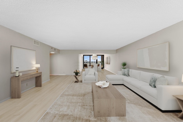 living room with a textured ceiling and light hardwood / wood-style floors