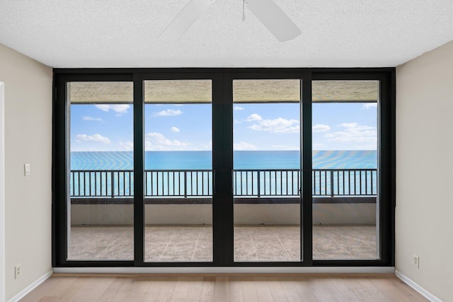 interior space featuring a water view, ceiling fan, and plenty of natural light