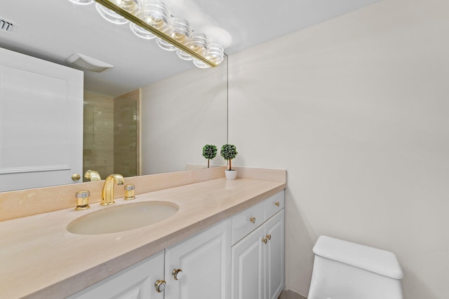 bathroom featuring toilet, an enclosed shower, and vanity