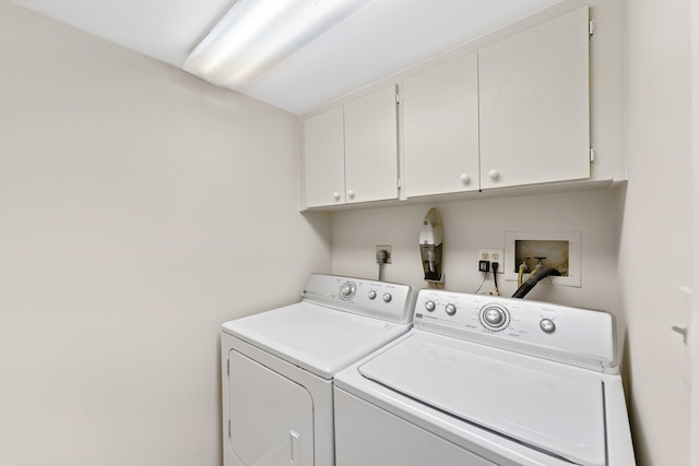 laundry room with washer and dryer and cabinets