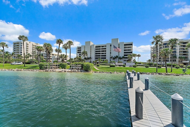 view of dock with a yard and a water view