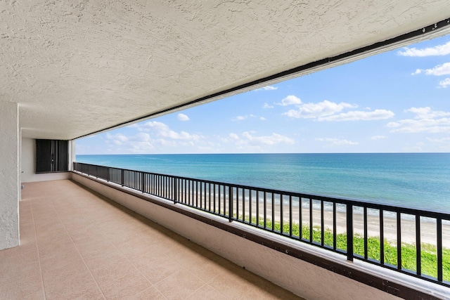 balcony featuring a water view and a beach view