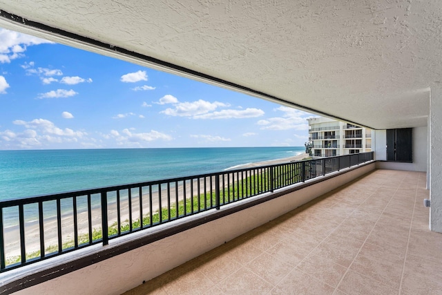 balcony with a water view and a beach view