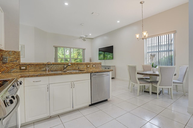 kitchen featuring dishwasher, hanging light fixtures, dark stone counters, white cabinetry, and white stove