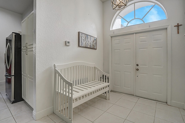 tiled foyer with a notable chandelier