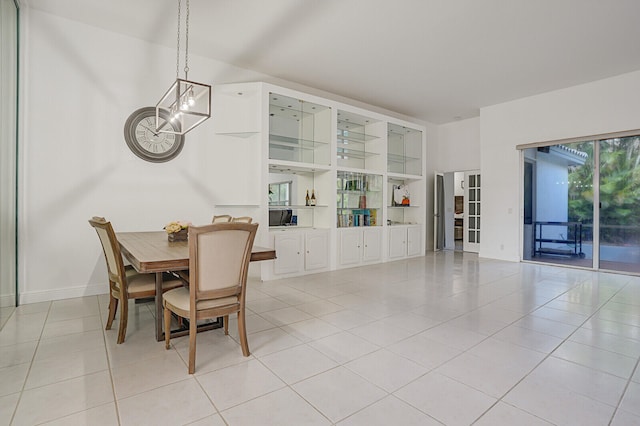 dining room featuring built in features, light tile patterned floors, and a chandelier