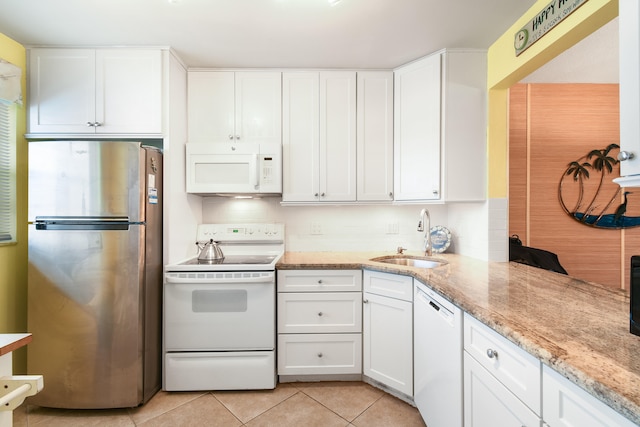 kitchen with decorative backsplash, sink, light stone countertops, white cabinetry, and white appliances