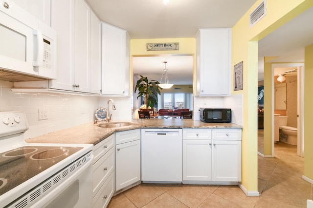 kitchen featuring white appliances, sink, white cabinetry, decorative backsplash, and light tile patterned floors